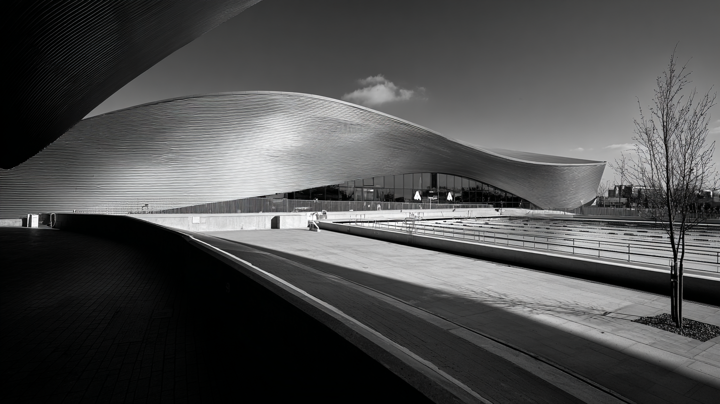Black and white photorealistic image of London Aquatics Centre in the UK designed by Zaha Hadid, featuring a sweeping, wave-like roof structure captured from a wide low-angle perspective under bright daylight.