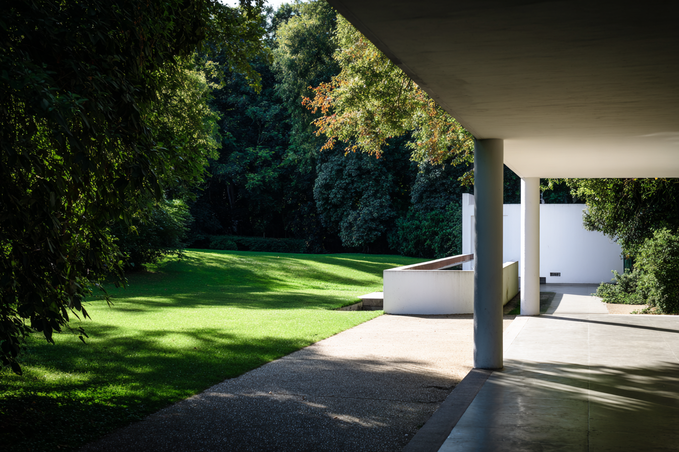 Photoreal render of Villa Savoye garden and terrace with morning light filtering through open pilotis, symbolizing spatial continuity in modernist architecture.