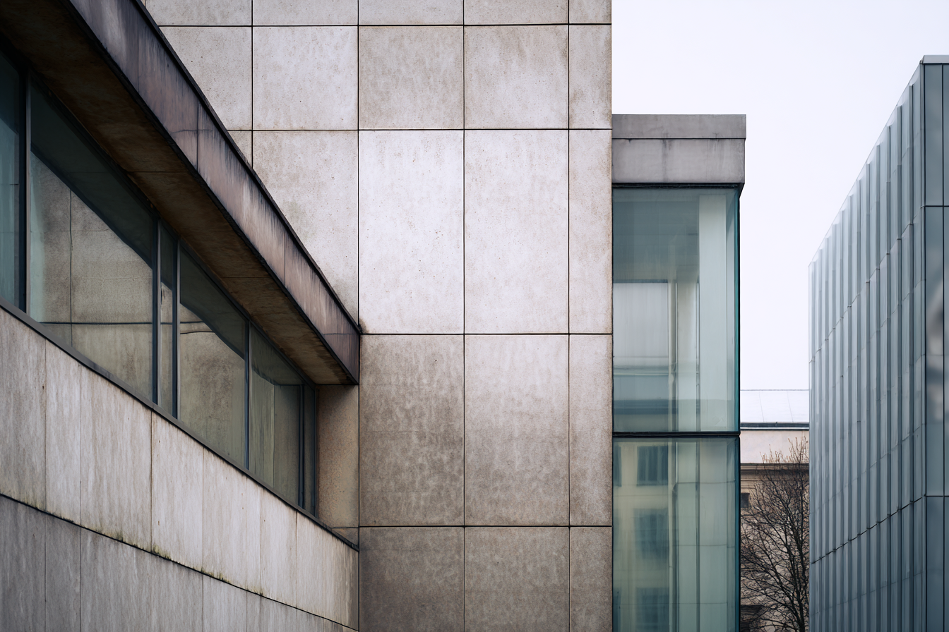 Close-up of modernist architecture showing plaster, glass, and steel surfaces in diffused overcast light, illustrating balance of material and minimalist design.
