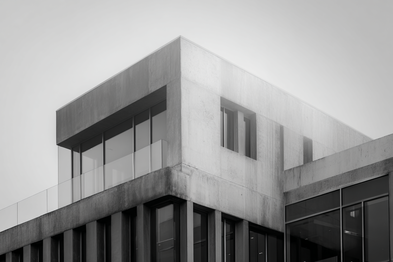 Modernist concrete and glass structure photographed in soft atmospheric light, emphasizing geometry, proportion, and minimalist composition.